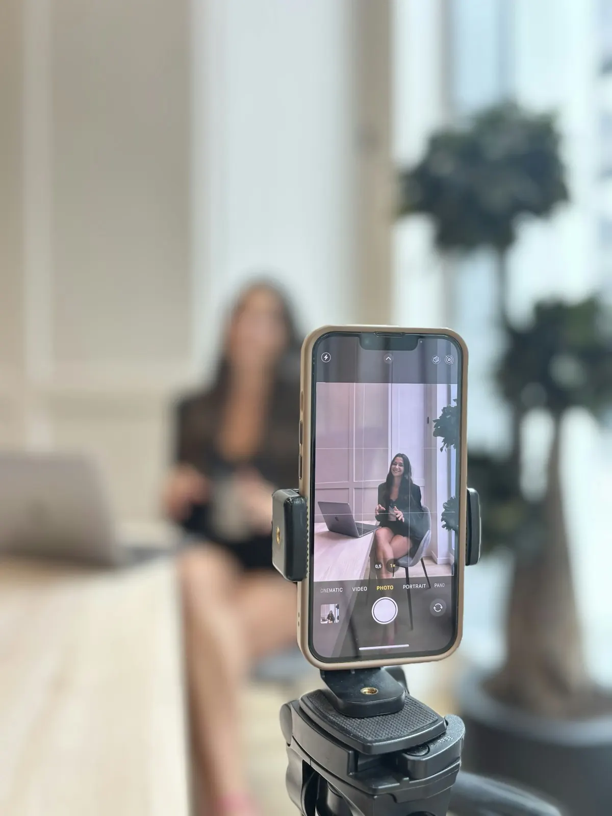 A phone on a tripod recording a woman presenting to camera